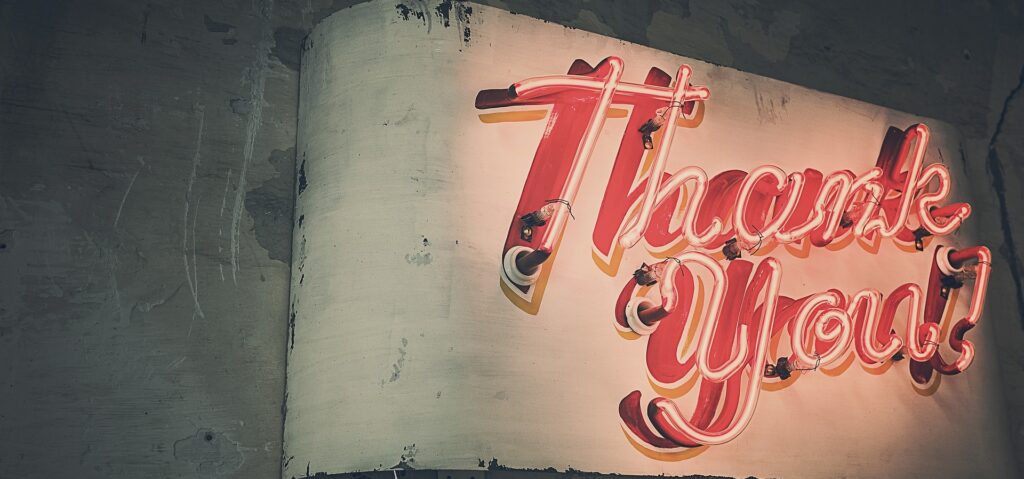 Leuchtschrift mit "Thank You" an Hauswand